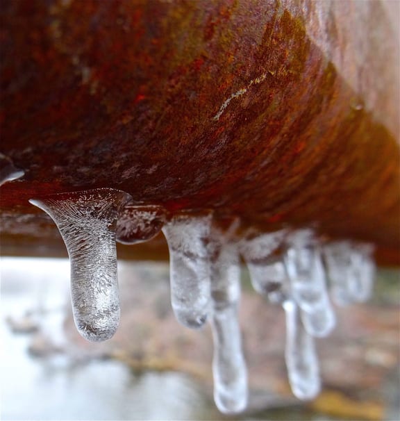 Close-Up Of Icicles Hanging On Rusty Pipe